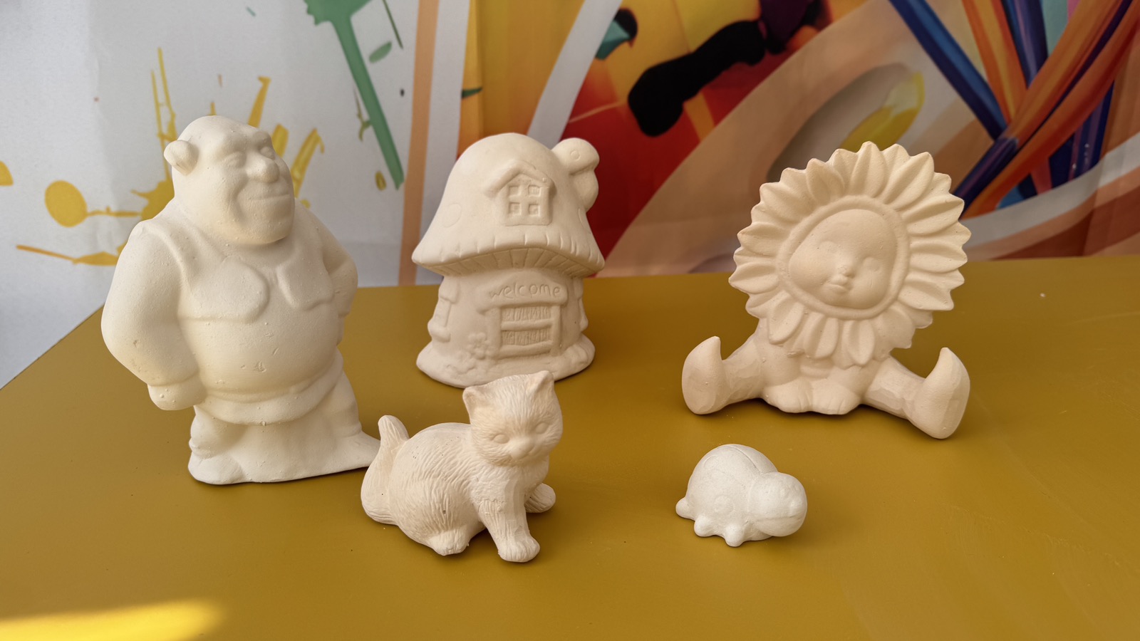 Широк изглед към ателието с маси за рисуване и керамика по рафтове